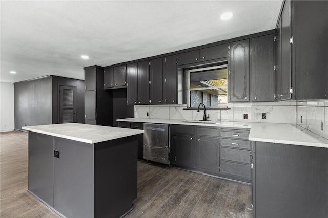 kitchen with a center island, sink, stainless steel dishwasher, dark hardwood / wood-style floors, and tasteful backsplash