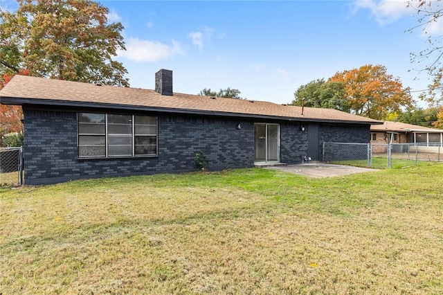 back of house with a patio and a lawn