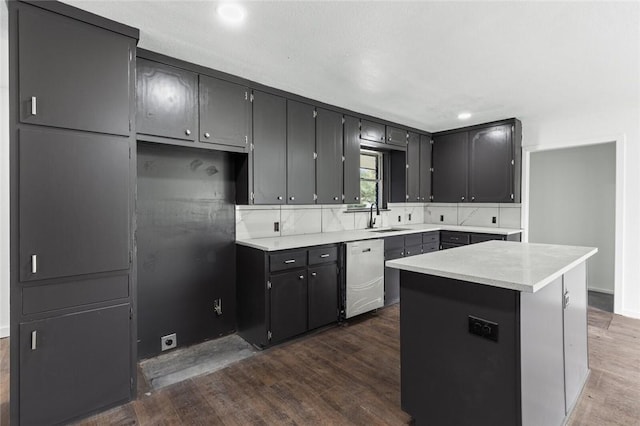 kitchen featuring dishwasher, a center island, sink, and dark wood-type flooring