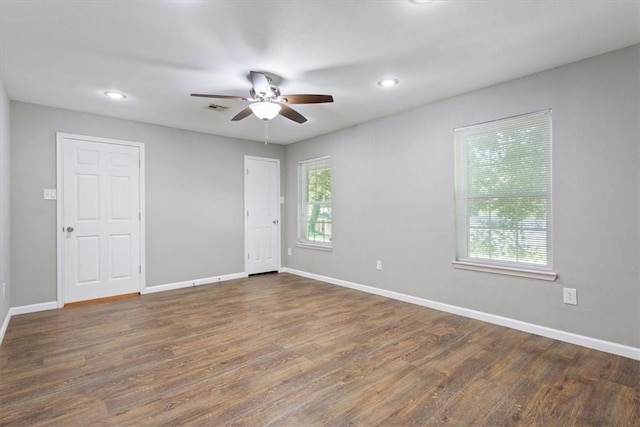 empty room with dark hardwood / wood-style floors and ceiling fan