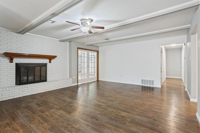 unfurnished living room with ceiling fan, beam ceiling, dark wood-type flooring, and a brick fireplace