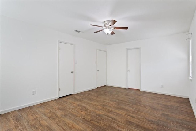 unfurnished room with dark hardwood / wood-style flooring and ceiling fan