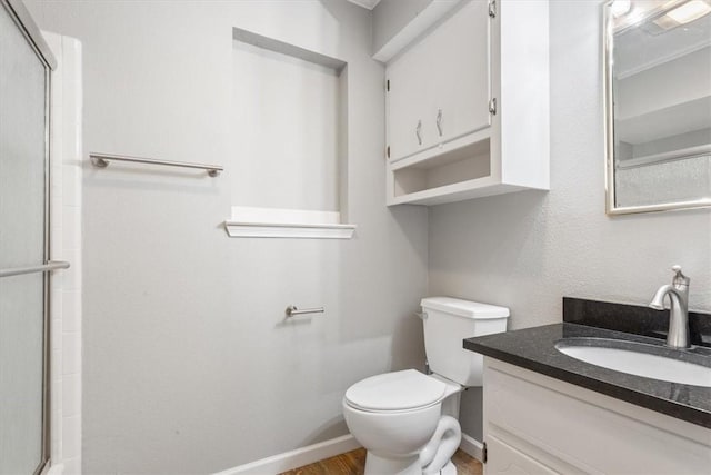 bathroom featuring vanity, hardwood / wood-style flooring, toilet, and a shower with shower door