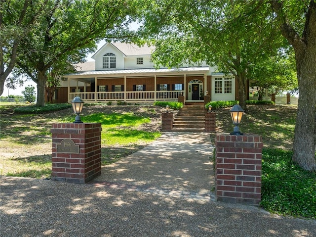 view of front of property featuring metal roof, a porch, and a standing seam roof