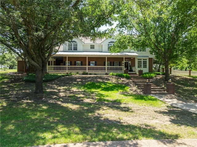 view of front facade with covered porch, brick siding, metal roof, and a standing seam roof