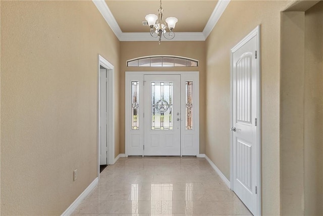 foyer entrance featuring crown molding and an inviting chandelier