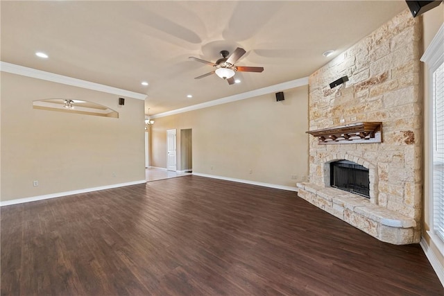 unfurnished living room with dark hardwood / wood-style floors, ceiling fan, a stone fireplace, and ornamental molding