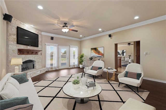 living room with hardwood / wood-style floors, ornamental molding, and a fireplace