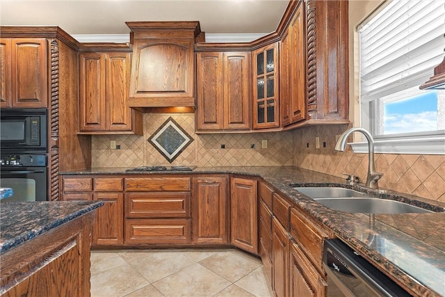 kitchen featuring dark stone counters, black appliances, sink, tasteful backsplash, and light tile patterned flooring