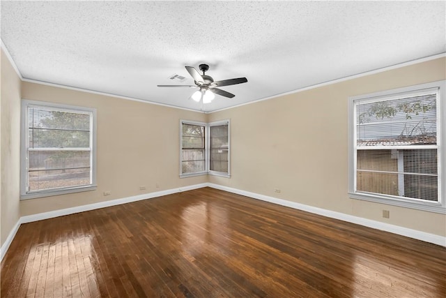 empty room with a textured ceiling, a healthy amount of sunlight, and dark wood-type flooring