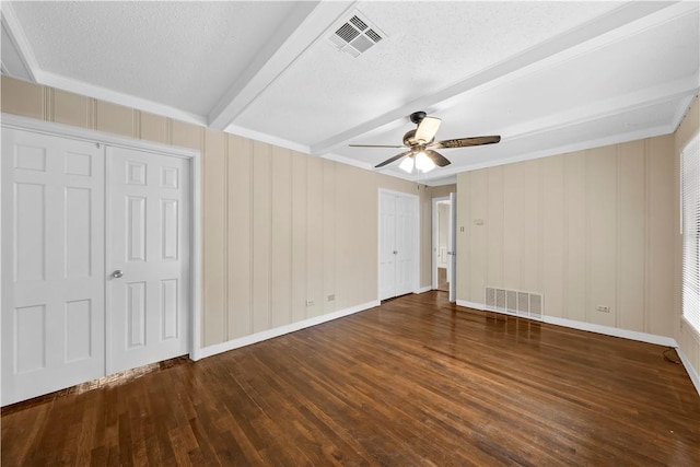 unfurnished bedroom with ceiling fan, beam ceiling, dark hardwood / wood-style flooring, and a textured ceiling