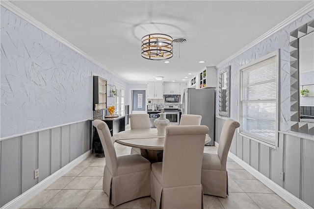 tiled dining space featuring a notable chandelier and ornamental molding