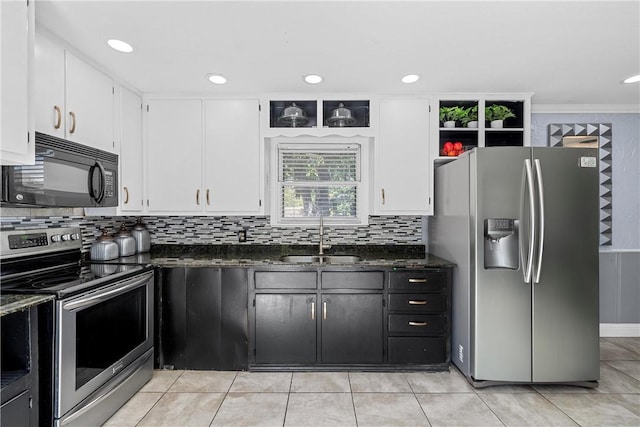 kitchen with dark stone countertops, ornamental molding, sink, and appliances with stainless steel finishes