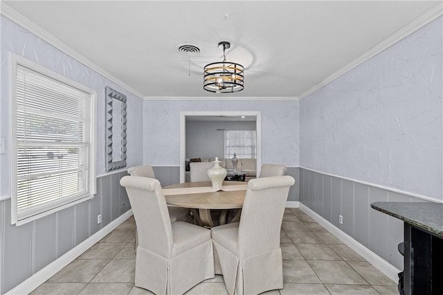 dining space with a notable chandelier, ornamental molding, and light tile patterned floors