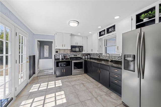 kitchen featuring sink, light tile patterned floors, crown molding, white cabinets, and appliances with stainless steel finishes