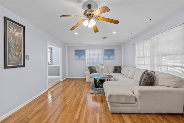 living room featuring ceiling fan and light hardwood / wood-style floors