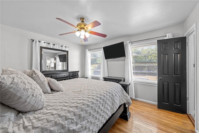 bedroom with light hardwood / wood-style floors and ceiling fan