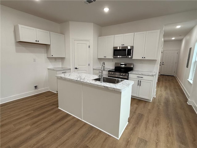 kitchen with stainless steel appliances, an island with sink, sink, and white cabinets