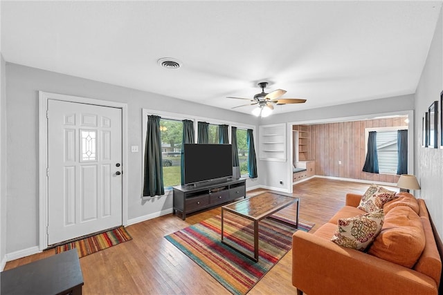 living room with light hardwood / wood-style floors and ceiling fan