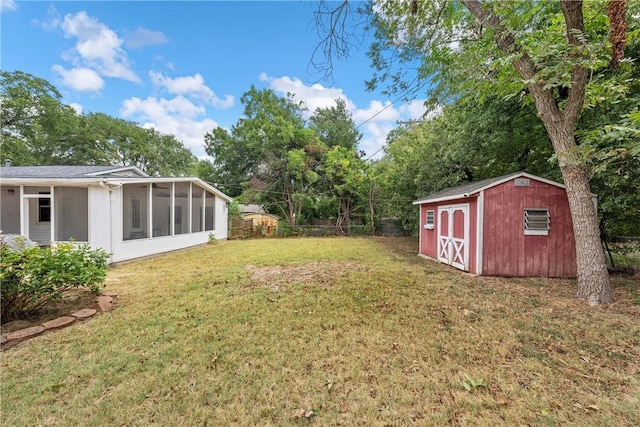 view of yard featuring a sunroom and a storage shed