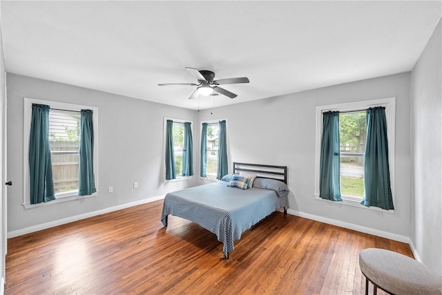 bedroom featuring multiple windows, ceiling fan, and hardwood / wood-style floors