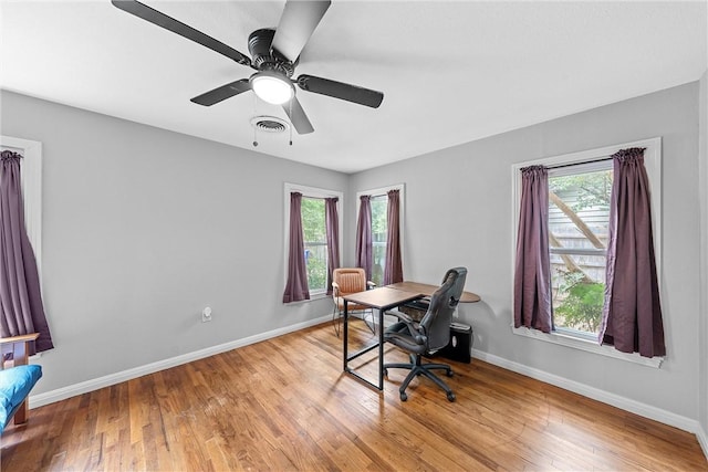 home office with ceiling fan, plenty of natural light, and light wood-type flooring