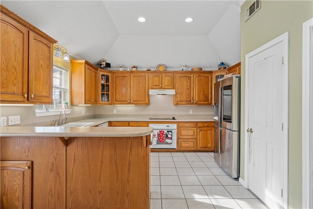 kitchen with vaulted ceiling, kitchen peninsula, stainless steel fridge, sink, and oven