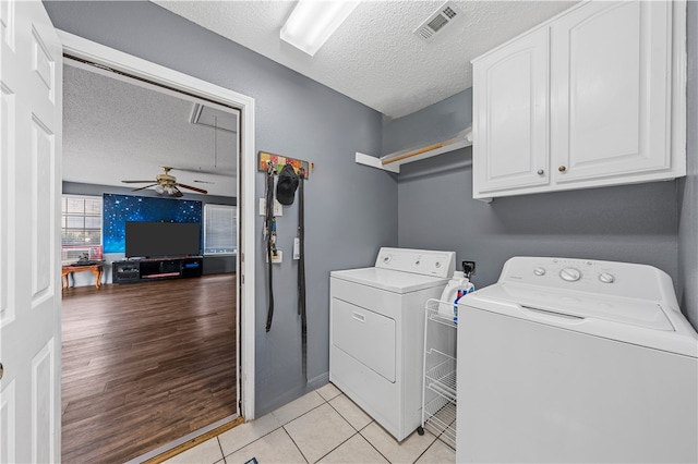 clothes washing area with a textured ceiling, cabinets, independent washer and dryer, ceiling fan, and light tile patterned floors