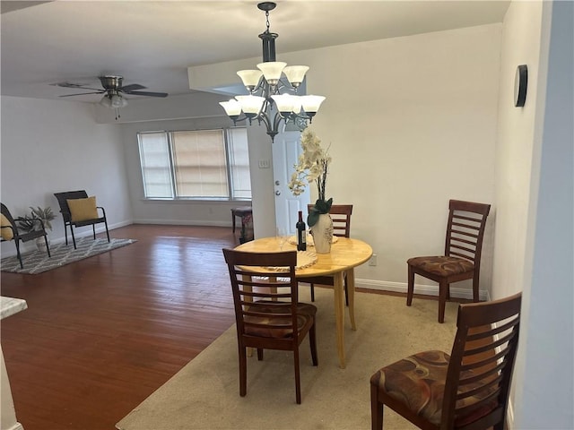 dining room featuring wood-type flooring and ceiling fan with notable chandelier