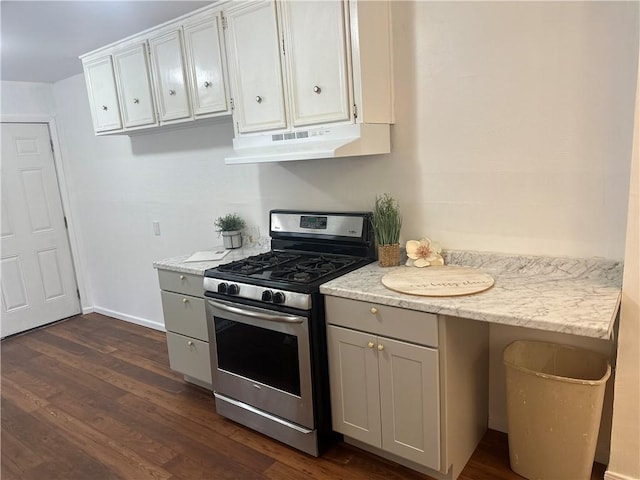 kitchen with light stone counters, white cabinets, dark wood-type flooring, and stainless steel gas range