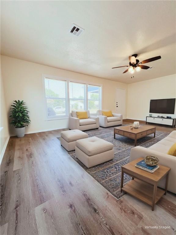 living room with ceiling fan and hardwood / wood-style flooring