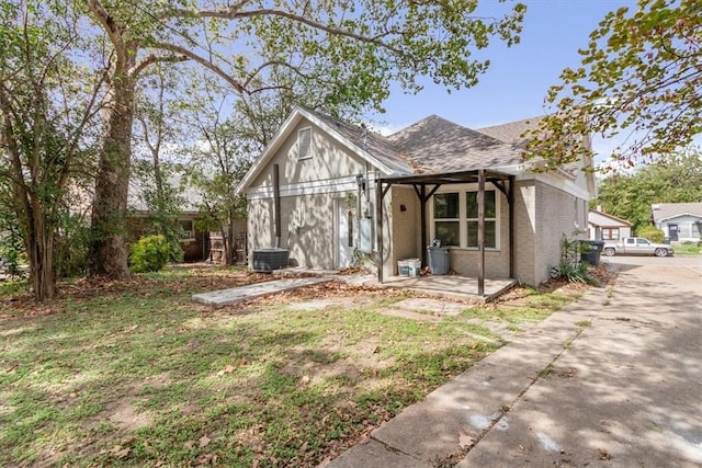 view of front of property with central AC and a front lawn