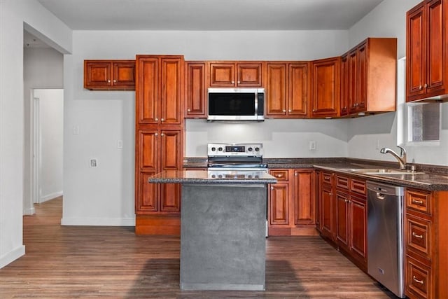 kitchen featuring a kitchen island, sink, stainless steel appliances, and dark wood-type flooring