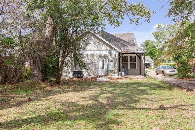 view of front of property with central air condition unit and a front lawn