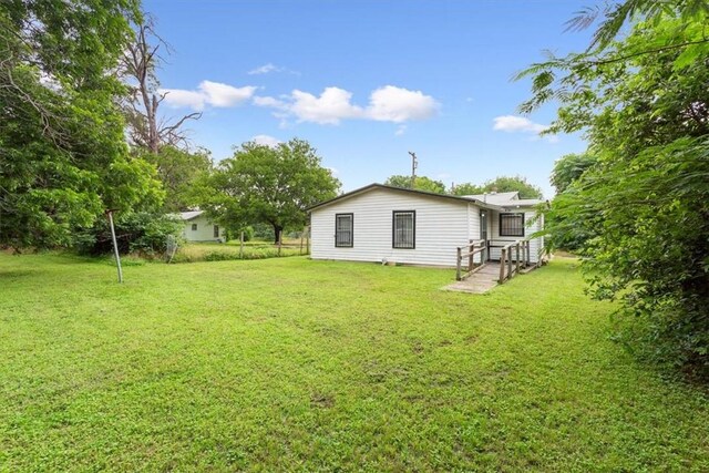 rear view of house featuring a deck and a lawn