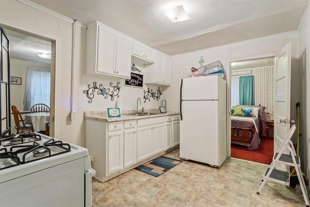 kitchen with white cabinetry, sink, white appliances, and ornamental molding