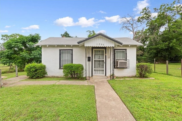 bungalow with cooling unit and a front lawn