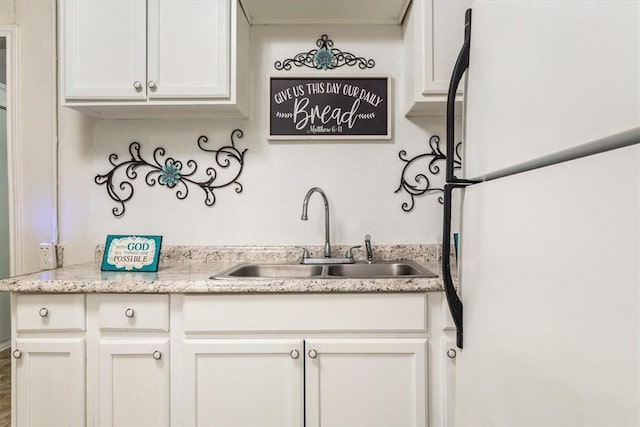 kitchen featuring white cabinets, white fridge, and sink