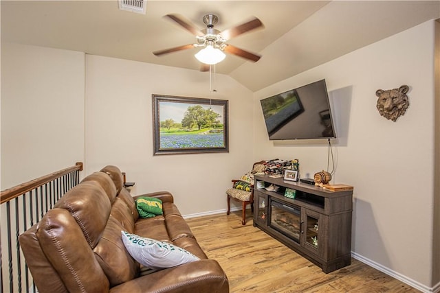 living room featuring light hardwood / wood-style flooring, vaulted ceiling, and ceiling fan