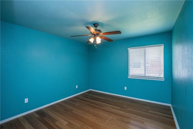 empty room featuring a textured ceiling, ceiling fan, and dark wood-type flooring