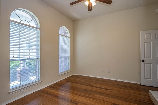 empty room featuring ceiling fan, dark wood-type flooring, and lofted ceiling