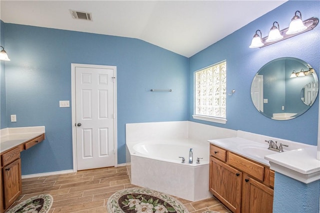 bathroom featuring a tub, vanity, wood-type flooring, and lofted ceiling