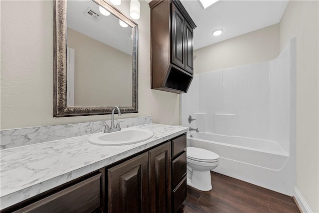 full bathroom with hardwood / wood-style floors, vanity, toilet, and tub / shower combination