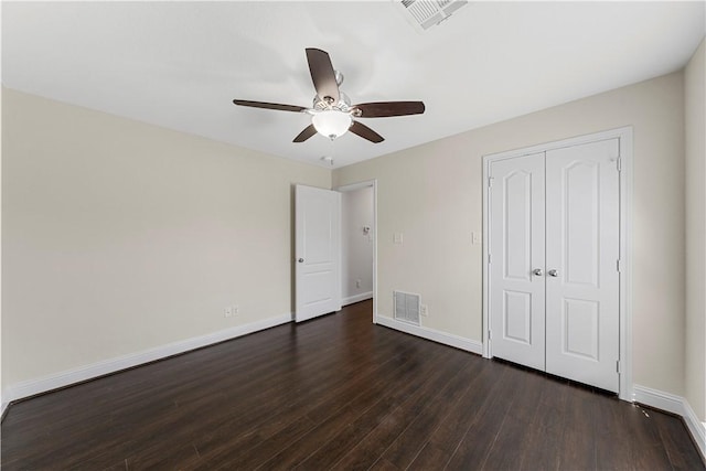 unfurnished bedroom with ceiling fan, dark hardwood / wood-style flooring, and a closet