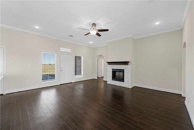 unfurnished living room with a fireplace, ornamental molding, ceiling fan, and dark wood-type flooring