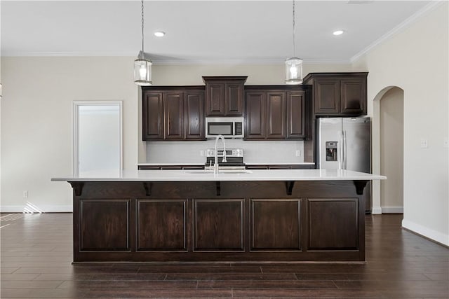 kitchen with a center island with sink, stainless steel appliances, and hanging light fixtures