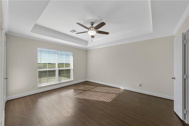 unfurnished room with dark hardwood / wood-style floors, crown molding, ceiling fan, and a tray ceiling