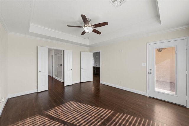 spare room with dark hardwood / wood-style flooring, a raised ceiling, and crown molding