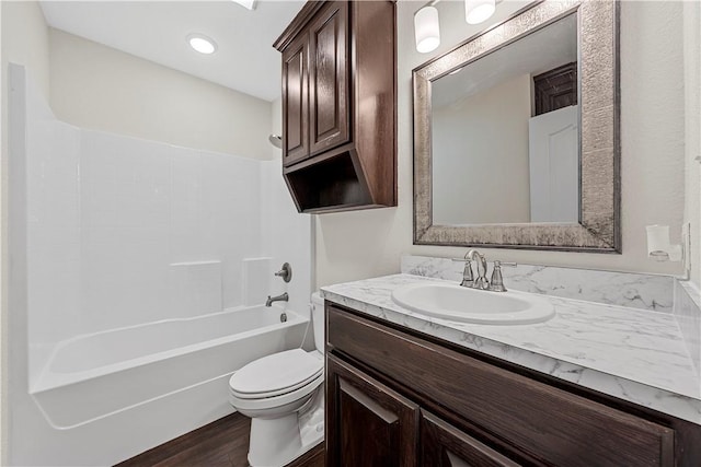 full bathroom featuring vanity, toilet, washtub / shower combination, and hardwood / wood-style flooring