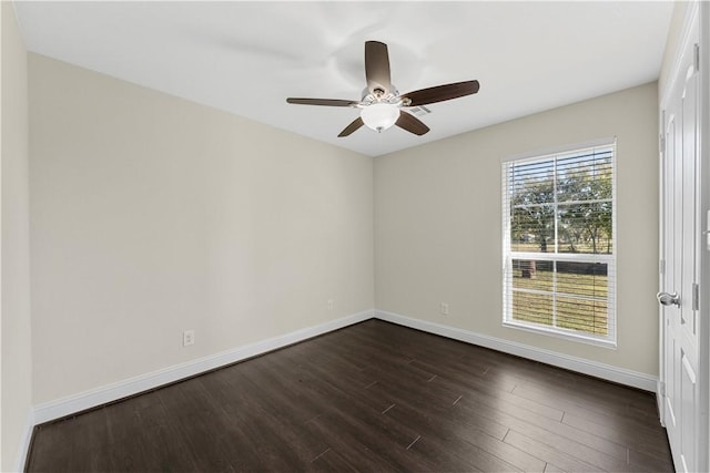 empty room with ceiling fan and dark wood-type flooring